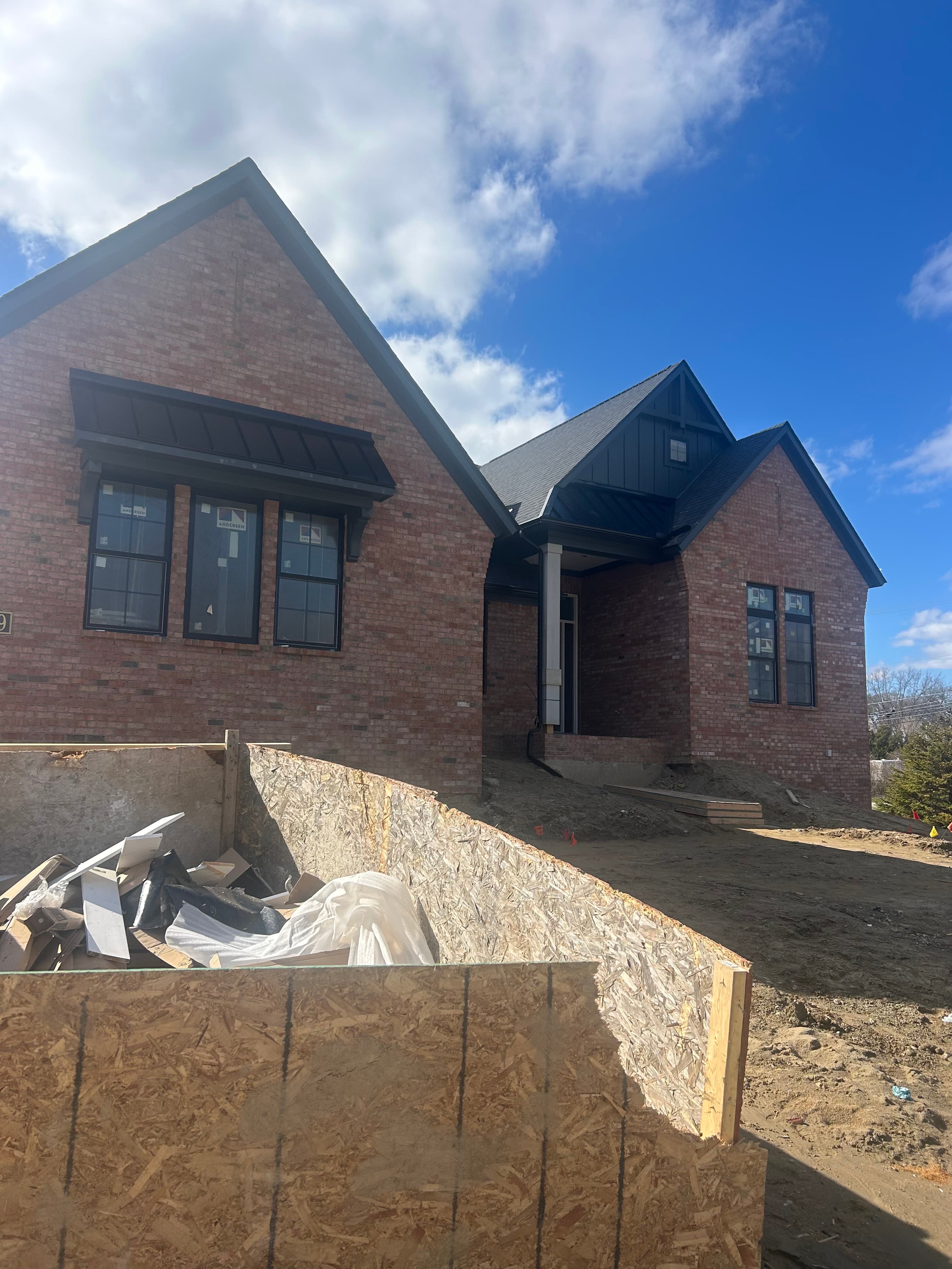 New Home Exterior : Brick Veneer & Dark Board-and-Batten Construction by JD Contracting LLC